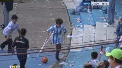 Niño jugando al fútbol con muletas en Argentina